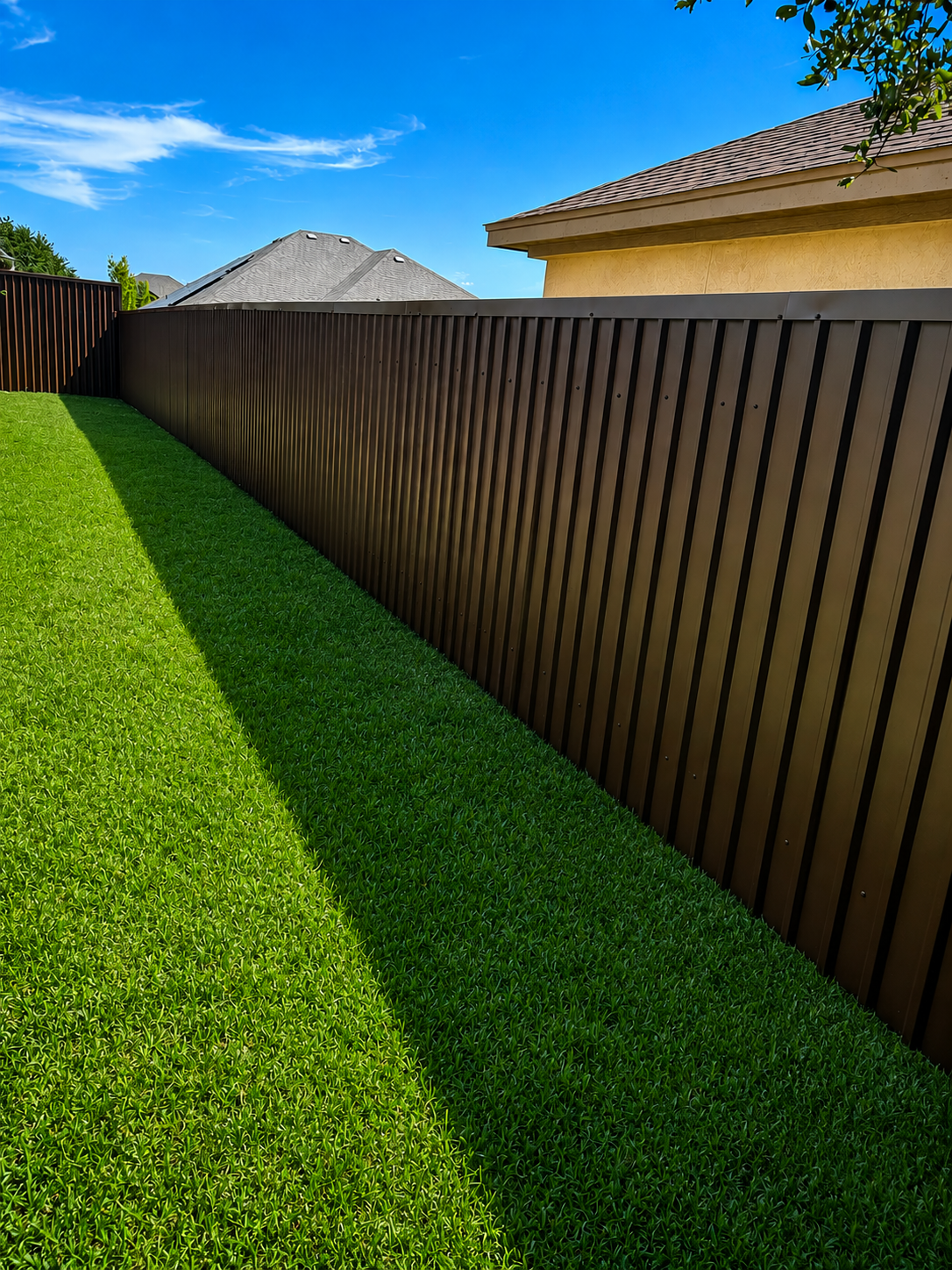 Modern dark brown vertical-slat fence green lawn fencing contractor Belton TX Martinez Construction